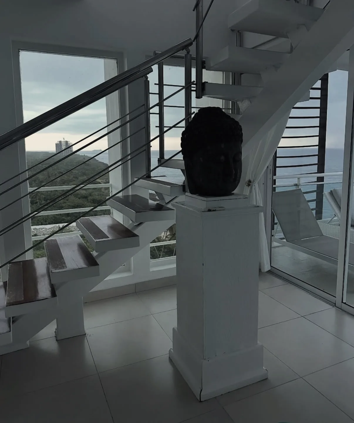 Offene Treppe mit Skulptur und Blick nach draußen